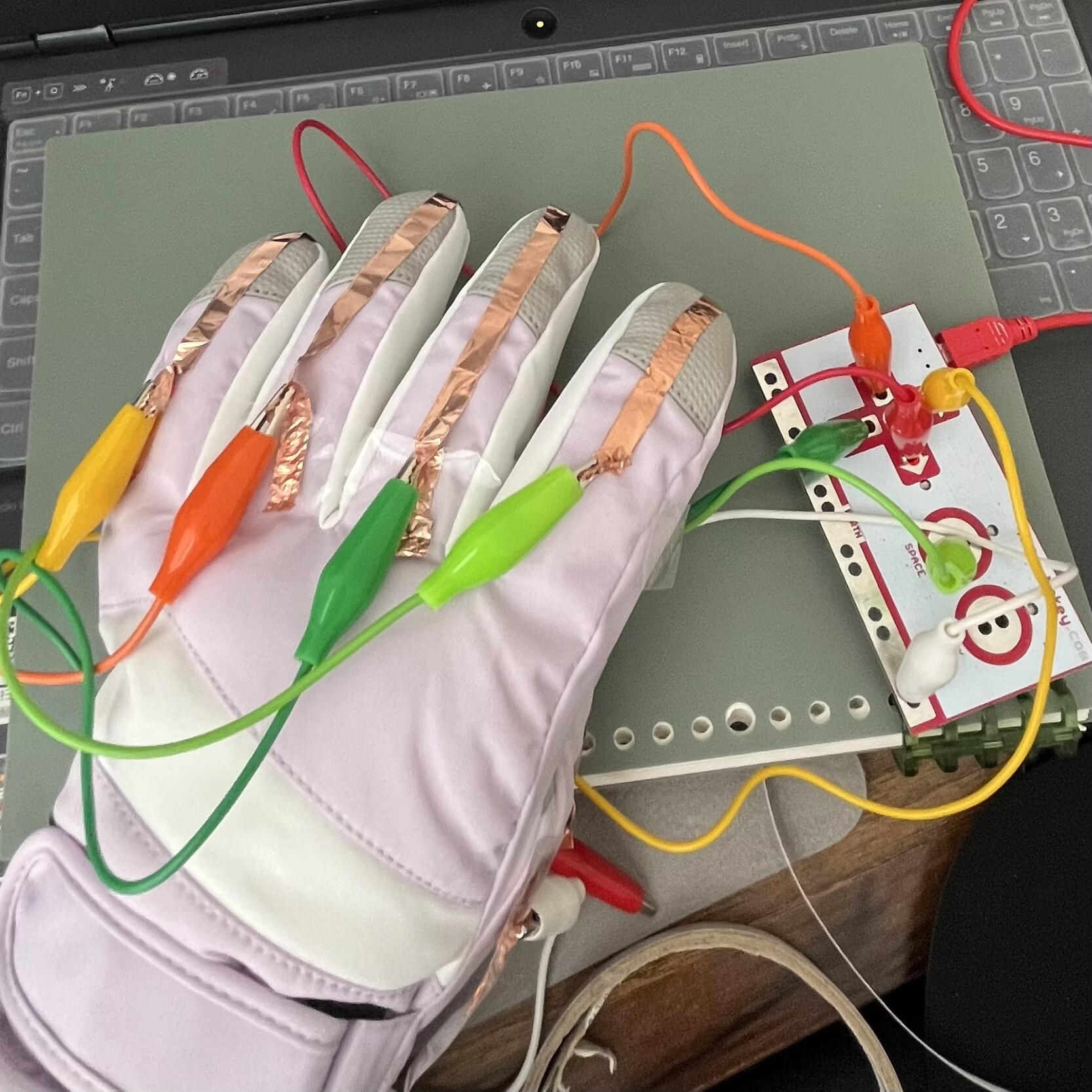 I used the glove from the previous module for this circuit. Each finger has copper tape, with the ground on the thumb. A connection is created when two fingers touch each other.